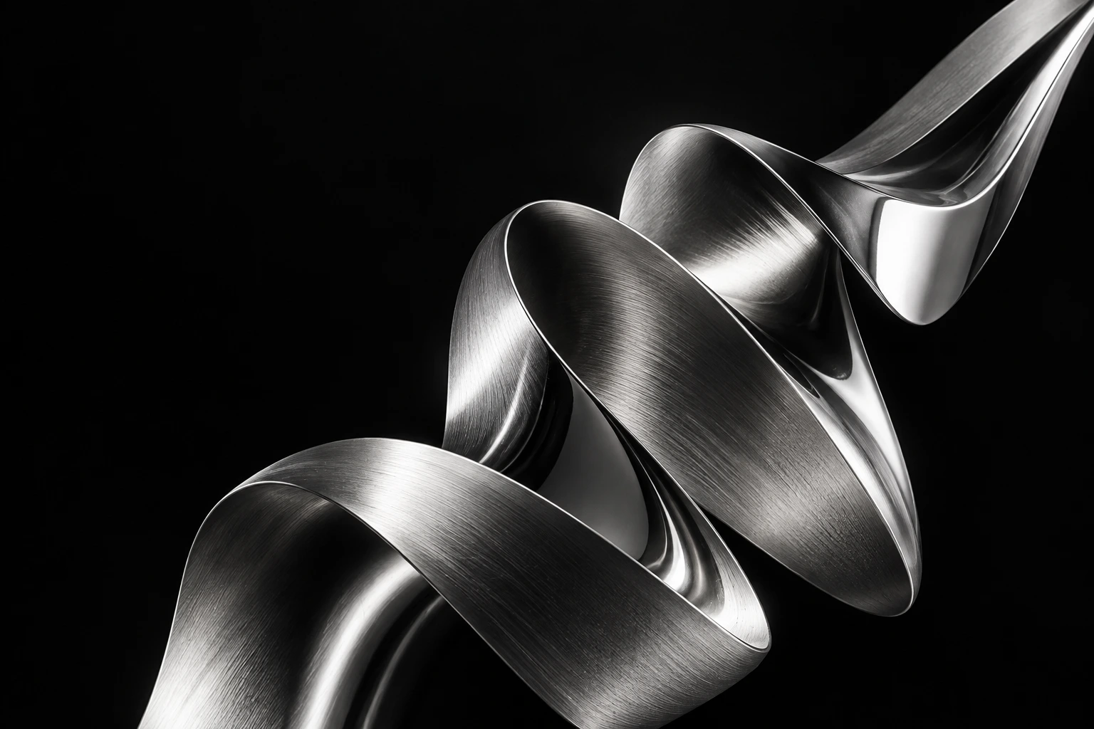 A sculptural silver ribbon moving from fluid folds into a clear direction